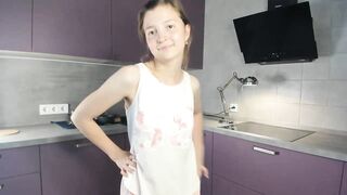 EmmaBacker - cute housewife in the kitchen dancing with her clothes on and shy to undress.